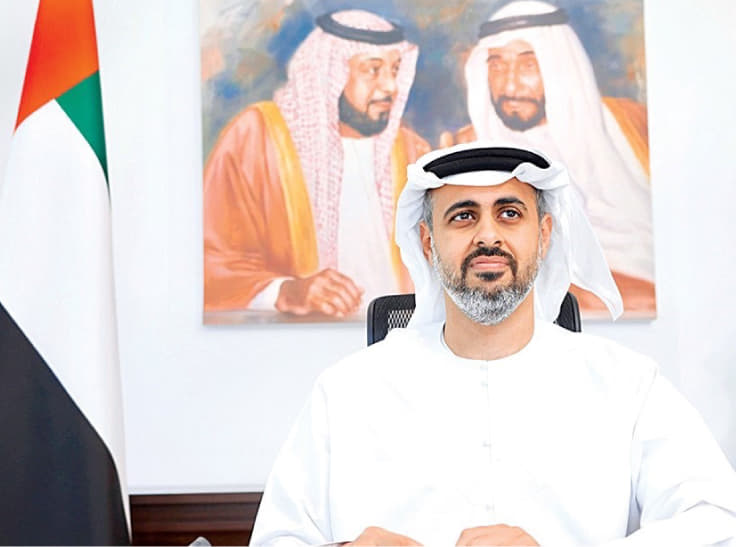 صورة لصاحب السمو الشيخ ثياب بن محمد بن زايد آل نهيان وهو جالس. وراءه علم دولة الإمارات العربية المتحدة وصورة على الجدار لصاحب السمو الشيخ زايد بن سلطان آل نهيان وصاحب السمو الشيخ خليفة بن زايد بن سلطان آل نهيان